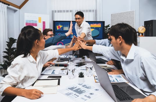 Analyst team leader celebrate with his colleague after successful data analysis meeting using FIntech software power with business intelligence or BI dashboard. Prudent