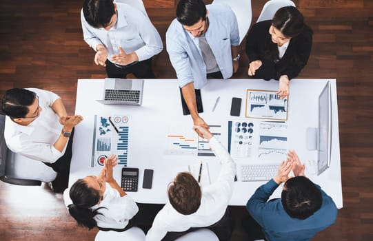 Top view diverse office employee worker shake hand after making agreement on strategic business marketing meeting. Teamwork and positive attitude create productive and supportive workplace. Prudent