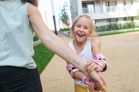 Mother helps daughter learn to roller skate