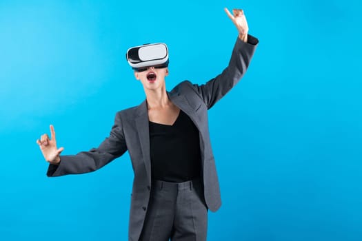 Caucasian business woman excited to explore visual reality world while standing and pointing at data. Skilled project manager wearing VR goggle and suit. Technology innovation concept. Contraption.