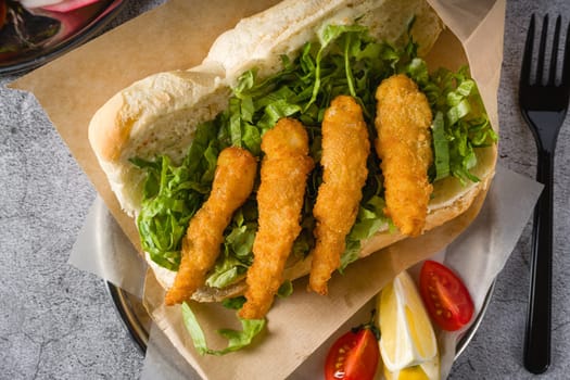 Deep fried shrimp in bread with greens on the side. Shrimp sandwich