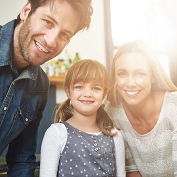 Kitchen, portrait and family with girl, smile and parents with happiness and bonding together. Face, mother and father with daughter, childhood and kid for hobby, activity and in home lens flare.