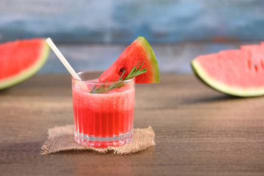 Glass of fresh watermelon juice on wooden table with copy space. Summer drink concept.