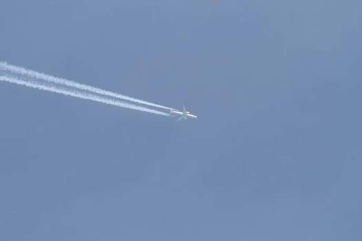 A gleaming white plane soaring gracefully in the vast sky.