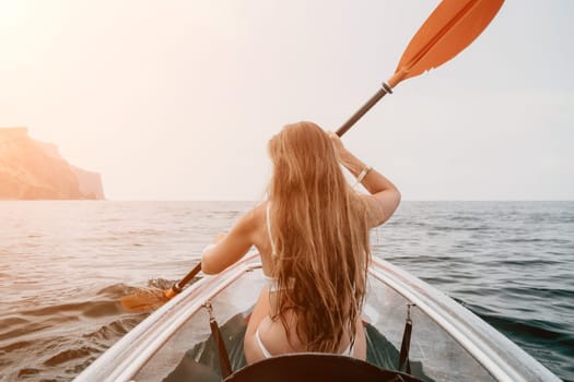 Woman in kayak back view. Happy young woman with long hair floating in transparent kayak on the crystal clear sea. Summer holiday vacation and cheerful female people having fun on the boat.