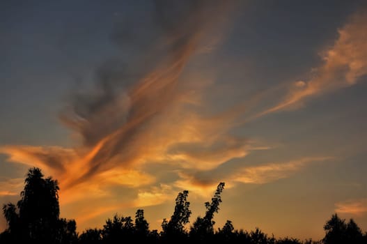 A breathtaking view of the sunset amidst the clouds, painting the sky with stunning hues, creating a mesmerizing and serene scene.