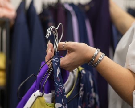 Close-up of woman's hands with hangers in a clothing store