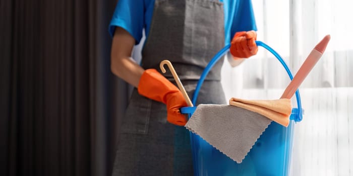 Cleaning product, and basket with woman staff cleaning service in bedroom to clean bacteria at apartment. cleaner or maid with container to work in room.