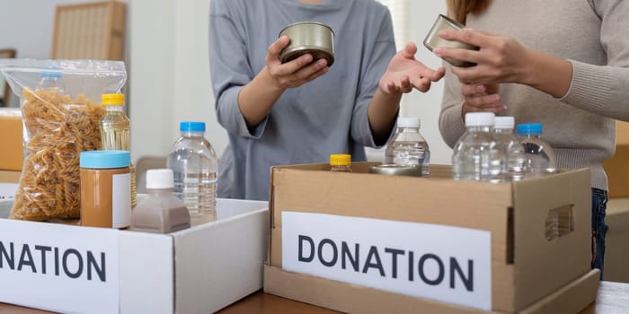 Volunteer preparing free foodstuff rations for poor people. Charity two woman of the community work together. concept of giving and humanitarian aid.