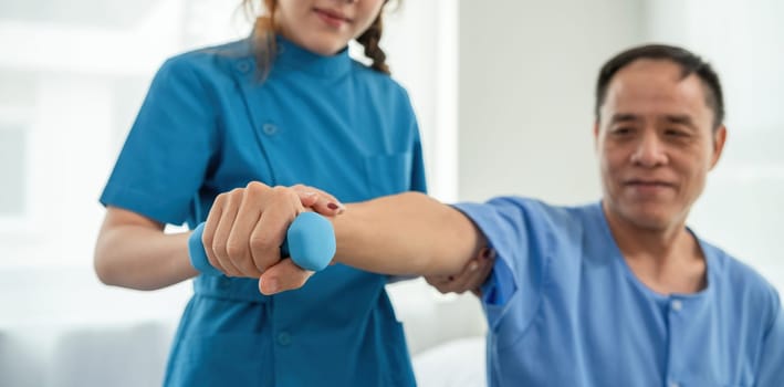 A sick caregiver or young nurse is helping a patient who is rehabilitating with physical therapy at the hospital..