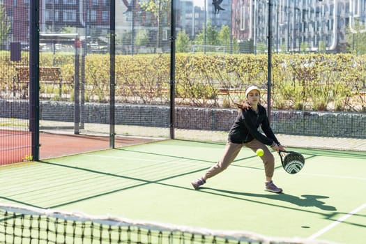 little girl playing padel and hitting the ball with his racket outdoors sports concepts. High quality photo