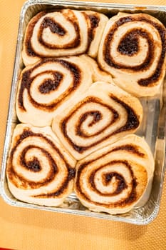 Just out of the oven, cinnamon rolls cool on a silicone baking mat, their icing glistening under the kitchen lights.