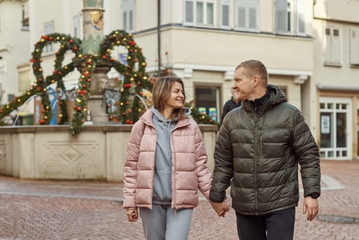 Loving couple of tourists walking around old town. Man woman couple walking europe old town Germany. Couple of lovers leisurely stroll in the cool autumn morning on the streets of a BIETIGHEIM-BISSINGEN (Germany). The guy holds his wife. Vacation, autumn, holiday. Couple Walking in Europe's Old Town