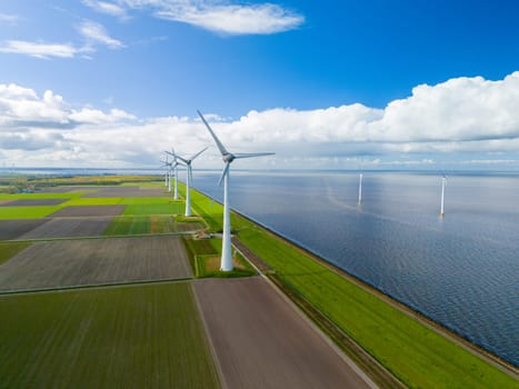 A mesmerizing aerial view of a wind farm with rows of majestic windmill turbines spinning gracefully near the vast ocean, harnessing energy from the gusts of wind.
