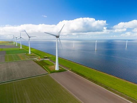 A mesmerizing aerial view of a wind farm near the ocean, where rows of elegant windmill turbines catch the breeze, harnessing clean energy.