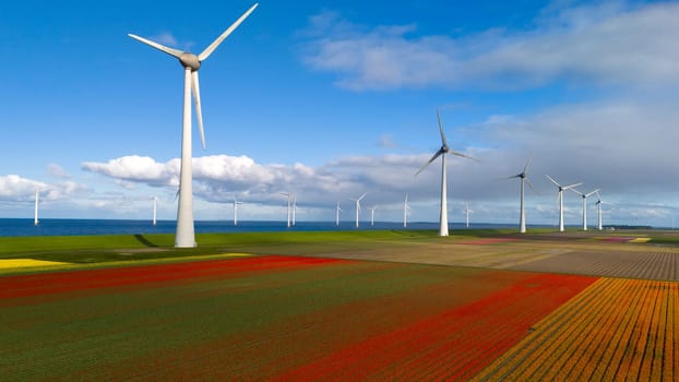 A serene landscape in the Netherlands, showcasing a wind farm with numerous windmills standing tall in the background, harnessing the power of the wind on a peaceful Spring day with colorful tulips