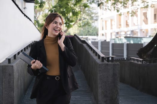 A woman is talking on her cell phone while walking down a stairway.