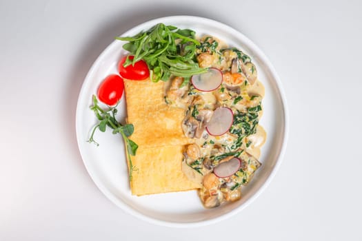 Savory crepe with creamy mushroom sauce, fresh greens on a white plate. Perfect for a light and satisfying meal.