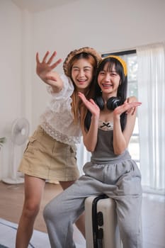 Two women are posing for a picture, one wearing a hat and the other wearing headphones. They are both smiling and seem to be having a good time
