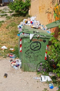 An overflowing trash bin presents a visible challenge in urban waste management, highlighting the need for increased collection and disposal efforts to maintain cleanliness in city streets