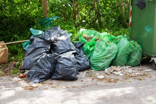 A scene of waste management unfolds with piles of green and black trash bags, representing the varied disposal needs and efforts in urban environments