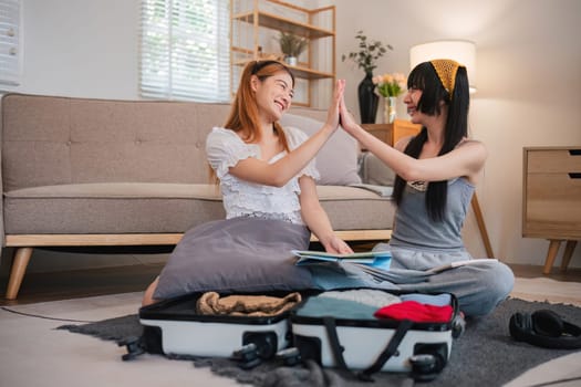 Two women are sitting on the floor, one of them is holding a map.