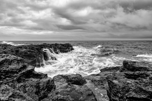 Stunning seascape with scenic clouds over the sea with rocky shore