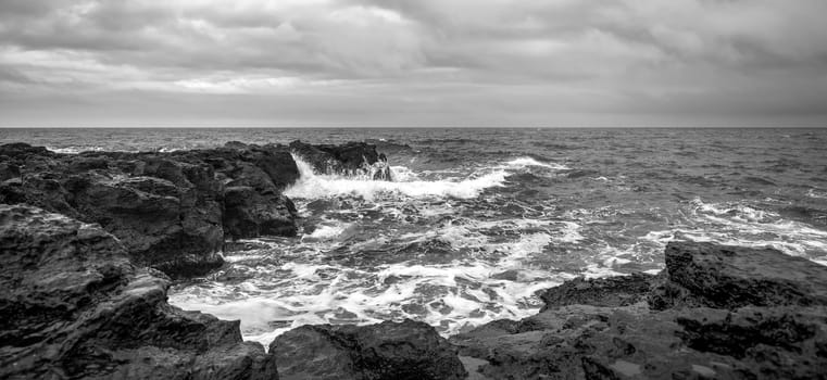 Panoramic seascape with scenic clouds over the sea with rocky shore