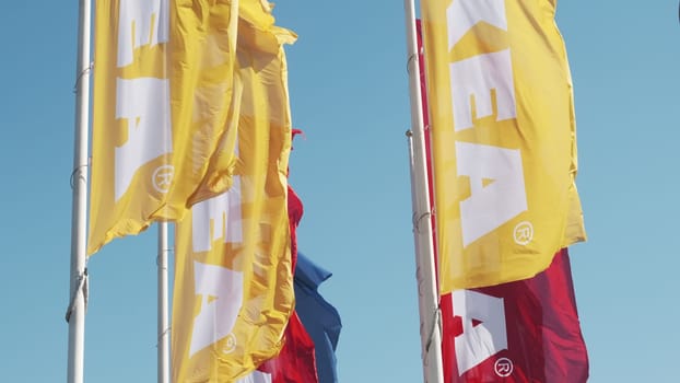 PRAGUE, CZECHIA -APRIL, 2024: Yellow and red IKEA flags waving in the wind against sky.