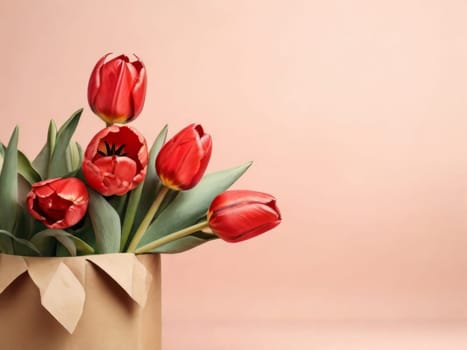 Beautiful red tulips in craft paper on beige pastel background with copy space, spring time, mother's day