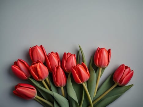 Beautiful red tulips in craft paper on gray pastel background with copy space, spring time, mother's day