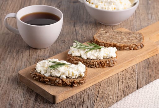 Homemade rye bread with cottage cheese in a plate and coffee. Healthy breakfast concept...