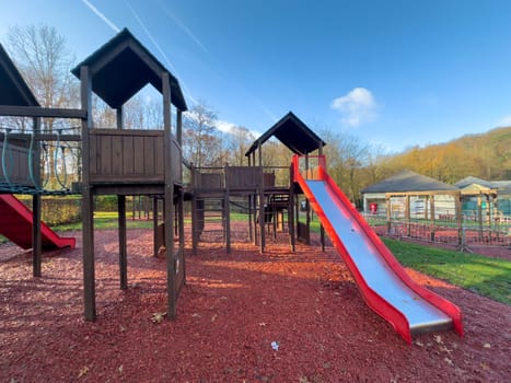 Colorful playground with climbing stairs and slides on yard in the park.