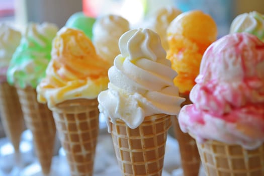 A row of ice cream cones are lined up on a table.