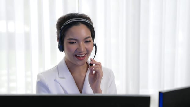 Businesswoman wearing vivancy headset working in office to support remote customer or colleague. Call center, telemarketing, customer support agent provide service on telephone video conference call