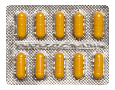 Oval yellow tablets in white plastic packaging, top view