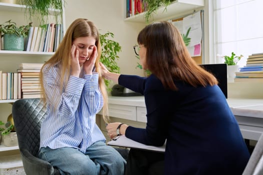 Sad upset young teenage female patient talking to professional mental therapist. Teenager girl high school college student in therapy with psychologist psychotherapist counselor. Psychological health