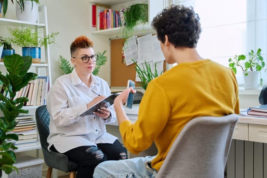 Female professional psychologist mental therapist working with young guy in office. Social worker counselor psychotherapist helping patient with difficulties stress depression. Psychology psychotherapy