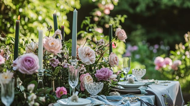 Table setting with rose flowers and candles for an event party or wedding reception in the summer garden.