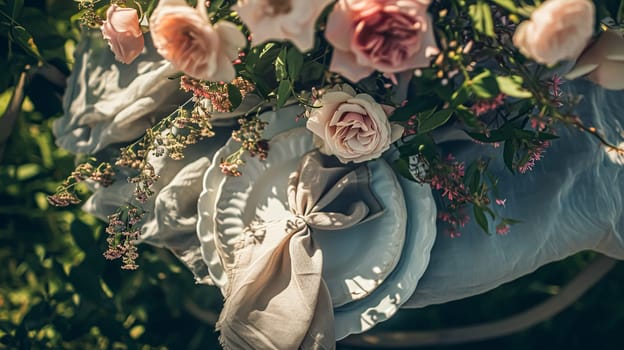 Table setting with rose flowers and candles for an event party or wedding reception in the summer garden.