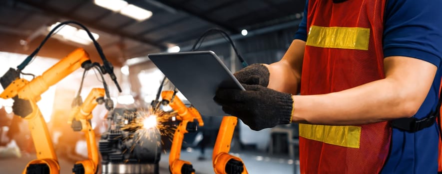 MLB Engineer use advanced robotic software to control industry robot arm in factory. Automation manufacturing process controlled by specialist using IOT software connected to internet network.