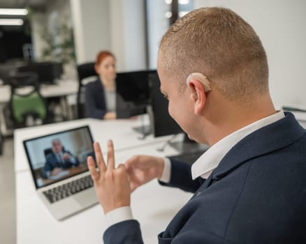 Business partners are talking in sign language to a video call. Two men at a remote business meeting