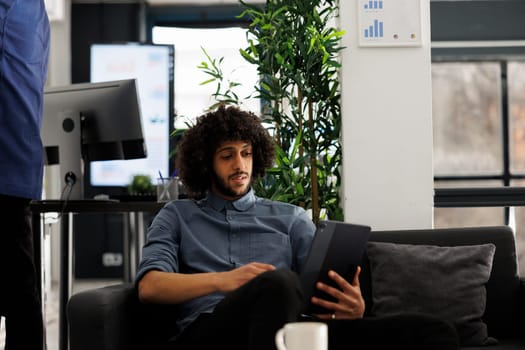 Executive manager preparing for marketing presentation using digital tablet in green office. Business company employee working at financial report and planning project development