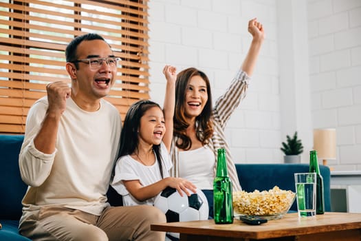 A family of fans gathers on the sofa to watch a football match on TV. Their cheers, encouragement, and togetherness reflect the joy of the game and the shared happiness in the room.