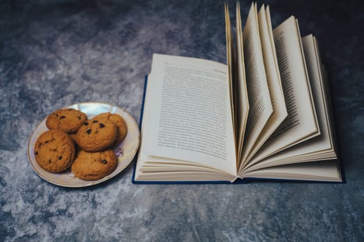 Open book next to a plate of cookies. High quality photo