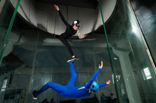 A man and a woman enjoy flying together in a wind tunnel. Free fall simulator.