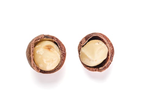 Two peeled macadamia nuts on white background with clipping path. Set of two macadamia nuts with open shells, isolated on white, top view or flat lay. Copy space for text.