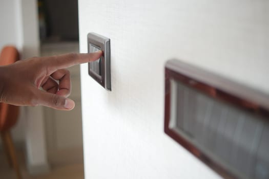 A finger turning on lighting switch