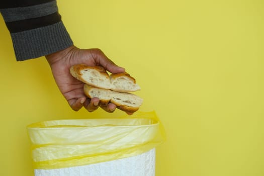 throwing old breads in a garbage bin ,