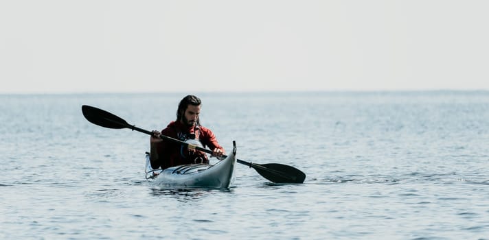 Happy smiling woman in kayak on ocean, paddling with wooden oar. Calm sea water and horizon in background